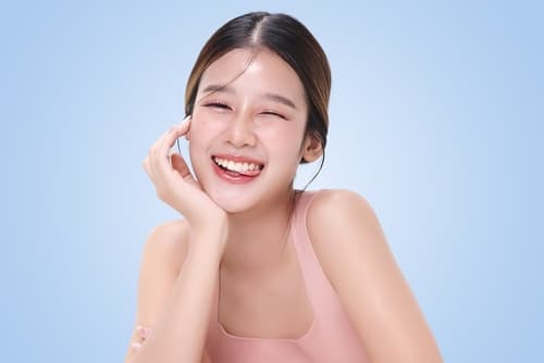 笑容自信的年輕女性展現潔白牙齒，代表藍光漂牙後的亮白效果